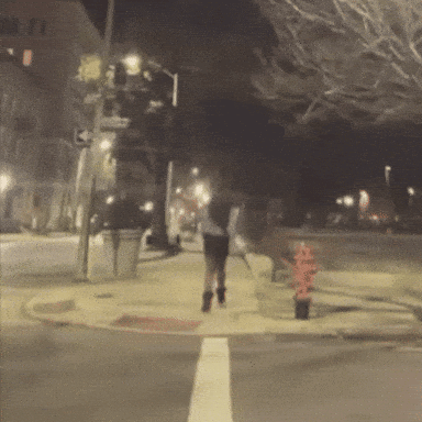 Blurry Person Walking on Sidewalk at Night
