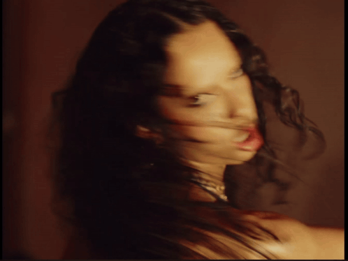 Blurry Photo Of Woman With Long Curly Hair GIF