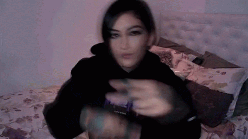 Blurry Woman Laying On Bed In Black Hoodie Saying Purple GIF