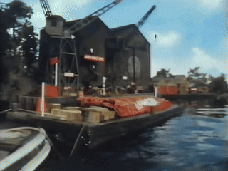 Boat in Water with Warehouse Sign