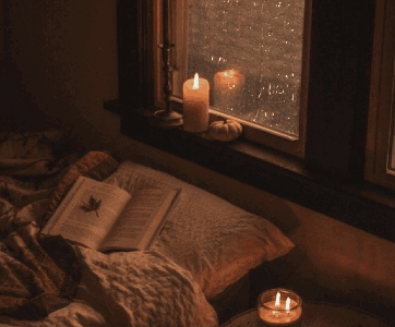 Book On Pillow By Window With Candles GIF