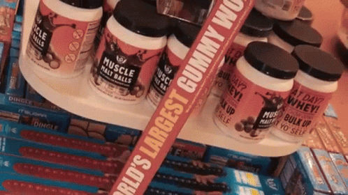 Bottles Of Muscle Mass Balls Are Stacked On A Shelf GIF