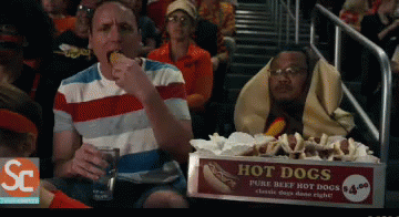 Box of Hot Dogs on Table in Front of Crowd