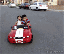 Boy and Girl Driving Red Mustang Toy Car