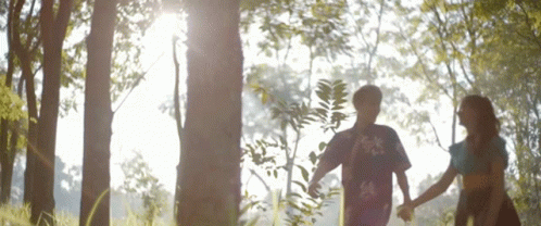 Boy And Girl Holding Hands In Woods GIF