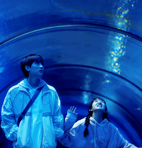 Boy And Girl Looking Up At Water In Tunnel GIF