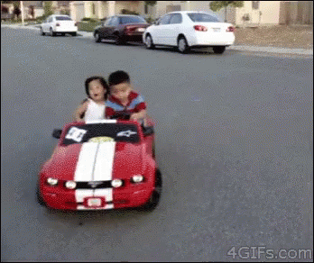 Boy and Girl Riding Red Toy Car