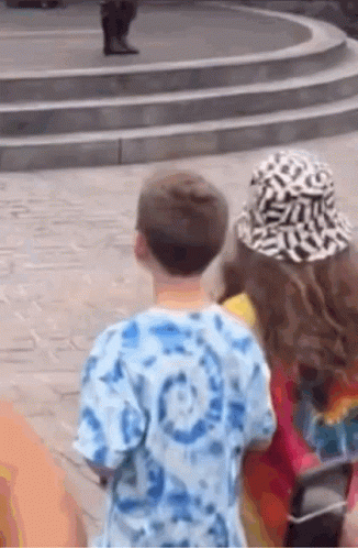 Boy and Girl Standing Next to Each Other Looking at Statue