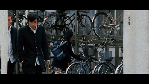 Boy and Girl Walking Past Bikes