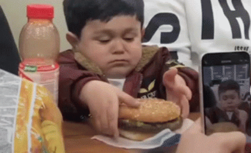 Boy Eating Hamburger Taking Photo