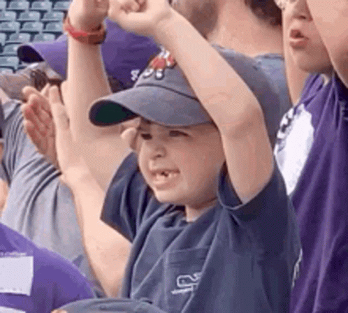 Boy in Baseball Cap Raising Fist