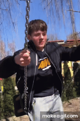 Boy in Black Jacket and An T-Shirt Swinging on Chain