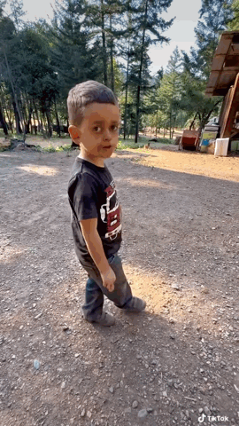 Boy in Black Thunder Shirt Standing in Dirt