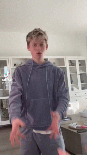 Boy In Blue Hoodie Standing In Living Room GIF