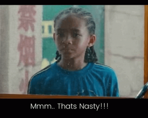 Boy in Blue Shirt Looking in Mirror Saying Mmm Thats Nasty