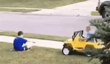 Boy in Blue Shirt Sitting Next to Yellow Toy Car