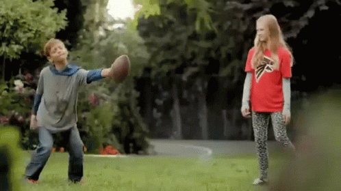 Boy in Falcons Shirt Playing Football with Girl