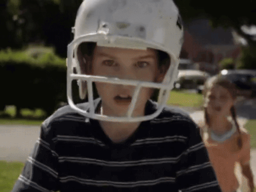 Boy in Football Helmet with Girl Behind
