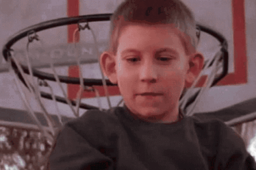 Boy in Front of Basketball Hoop Saying Hoop