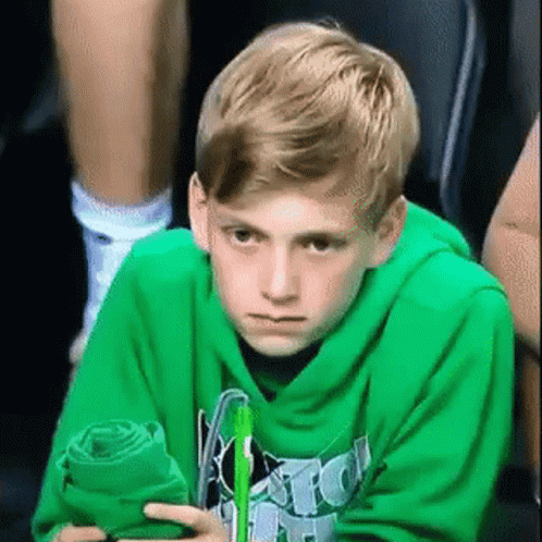 Boy In Green Hoodie Sitting With Towel And Pen GIF