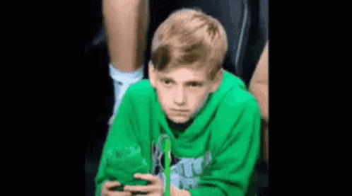 Boy in Green Hoodie Using Phone