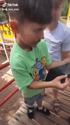 Boy in Green Sleep Shirt Looking at Phone