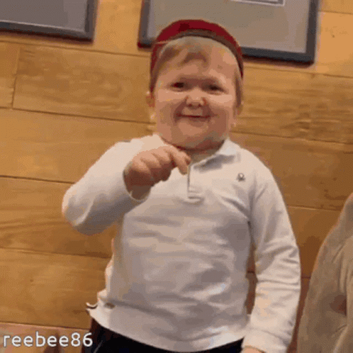 Boy In Hat Smiling Holding Toothpick GIF