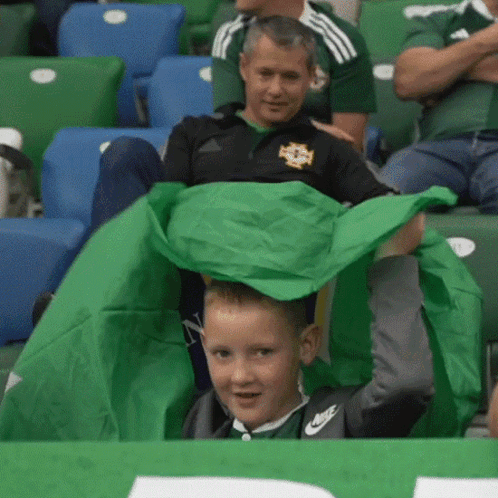 Boy in Nike Shirt Holding Green Cloth
