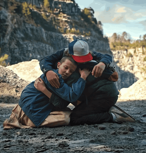 Boy In Red Hat Hugging Another Boy GIF