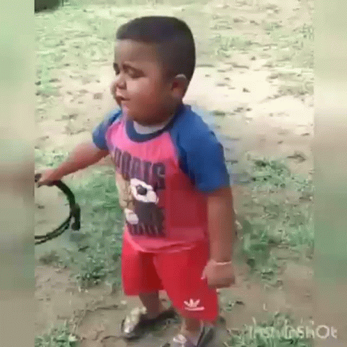 Boy in Red Shirt and Shorts Holding Tambourine