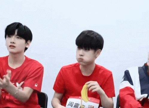 Boy in Red Shirt Eating Banana Wearing Lucky Tag