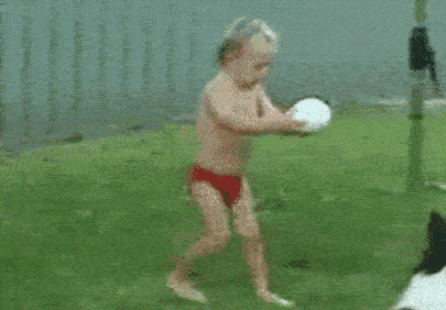 Boy in Red Swim Trunks Running Toward Ball