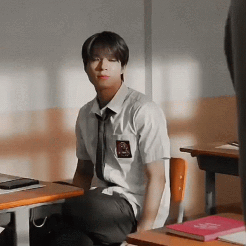 Boy in School Uniform Sitting at Desk