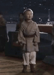 Boy In Star Wars Costume With Lightsaber GIF