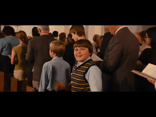 Boy in Striped Vest Standing in Crowd