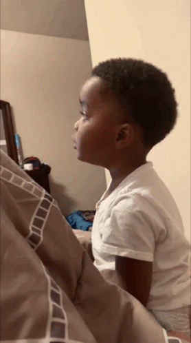 Boy In White Shirt Sitting On Bed GIF