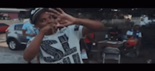 Boy in White Shirt With Letter S Making Peace Sign