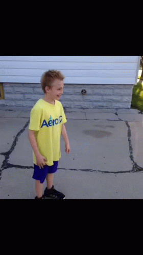 Boy In Yellow Aeropostale Shirt On Sidewalk GIF
