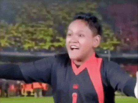 Boy Making Funny Face Arms Outstretched Soccer Field