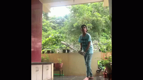 Boy Playing Cricket on Balcony