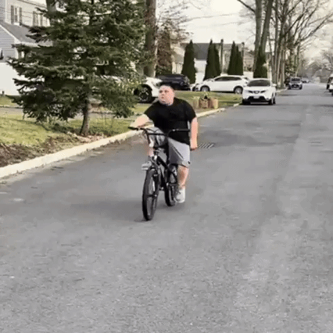 Boy Riding Bike Down Street