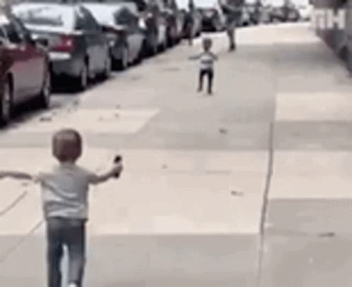 Boy Riding Scooter Down Sidewalk