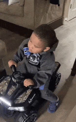 Boy Riding Toy Car In Living Room GIF