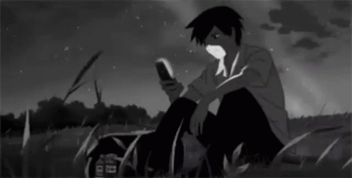 Boy Sitting In Grass Looking At Phone GIF