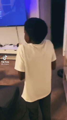 Boy Standing in Front of TV With Tik Tok