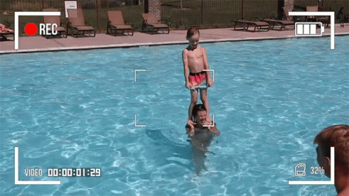 Boy Standing on Man's Shoulders in Pool