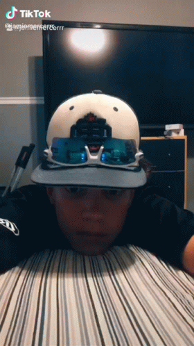Boy Wearing Hat and Sunglasses Lying on Bed