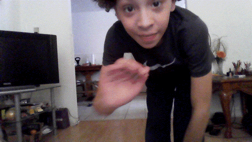 Boy Wearing Nike Shirt Standing in Front of Television