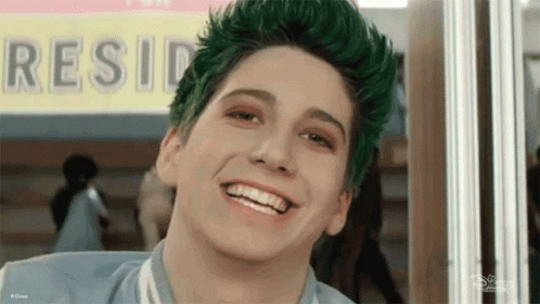 Boy with Green Hair Smiling in Front of Resid Sign