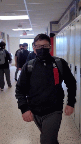 Boy With Mask and Glasses Walking Hallway